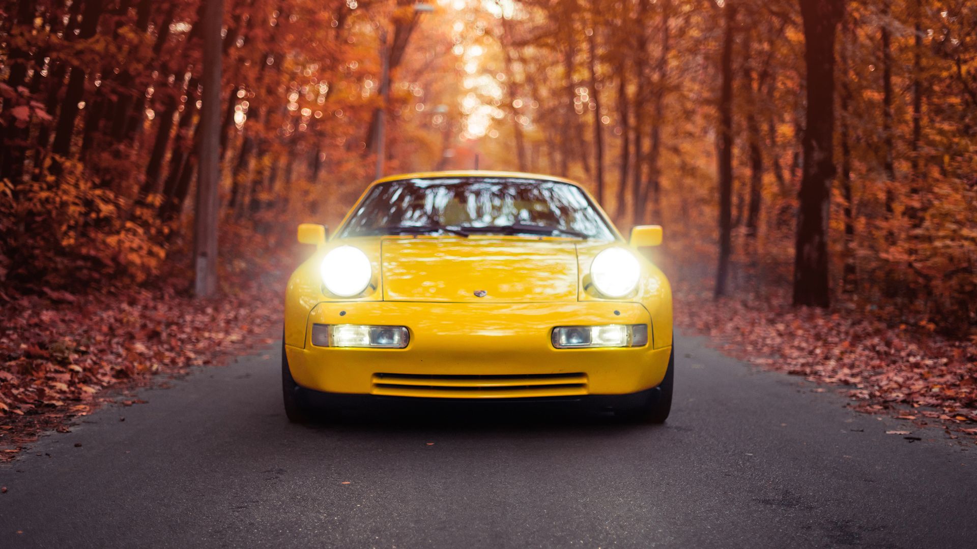 En gul Porsche kjører på høstveier